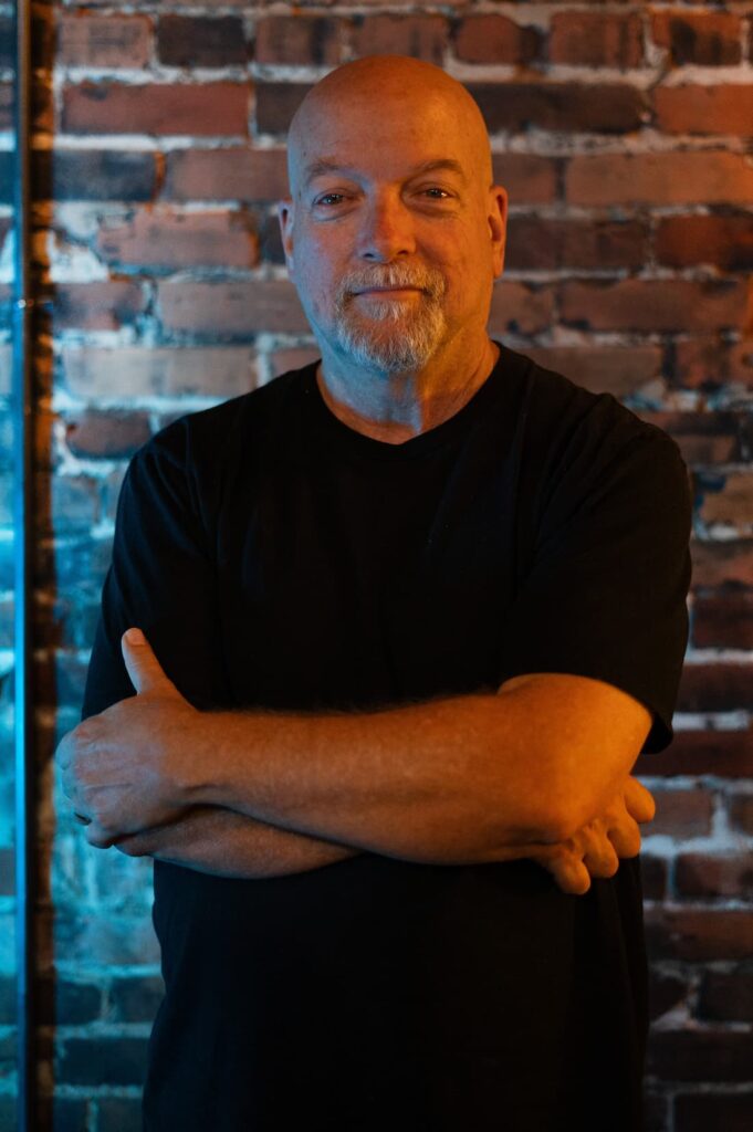 Jim Morris in front of a brick wall