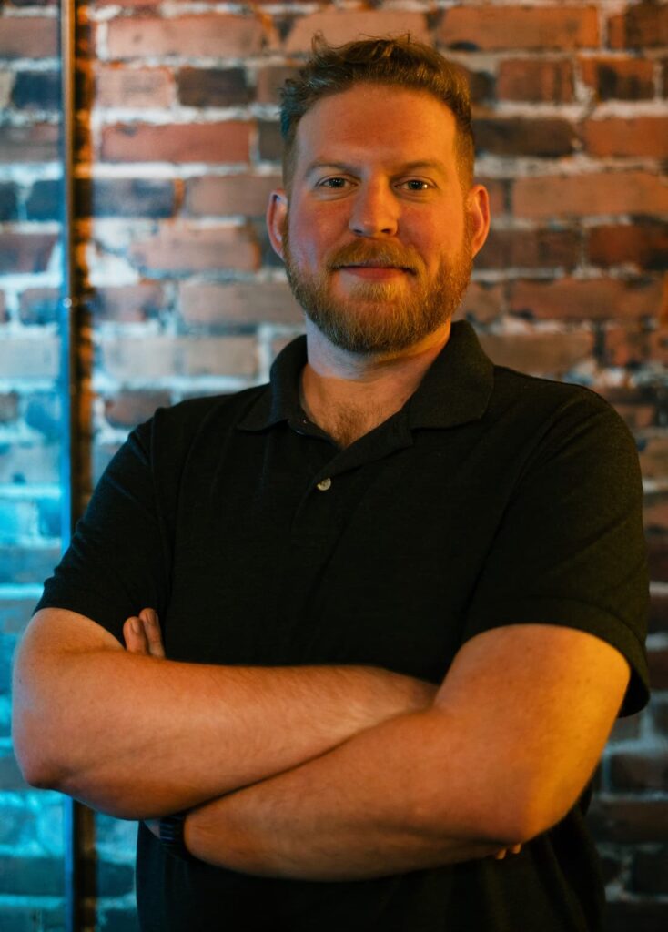 Jon Tucker in front of a brick wall