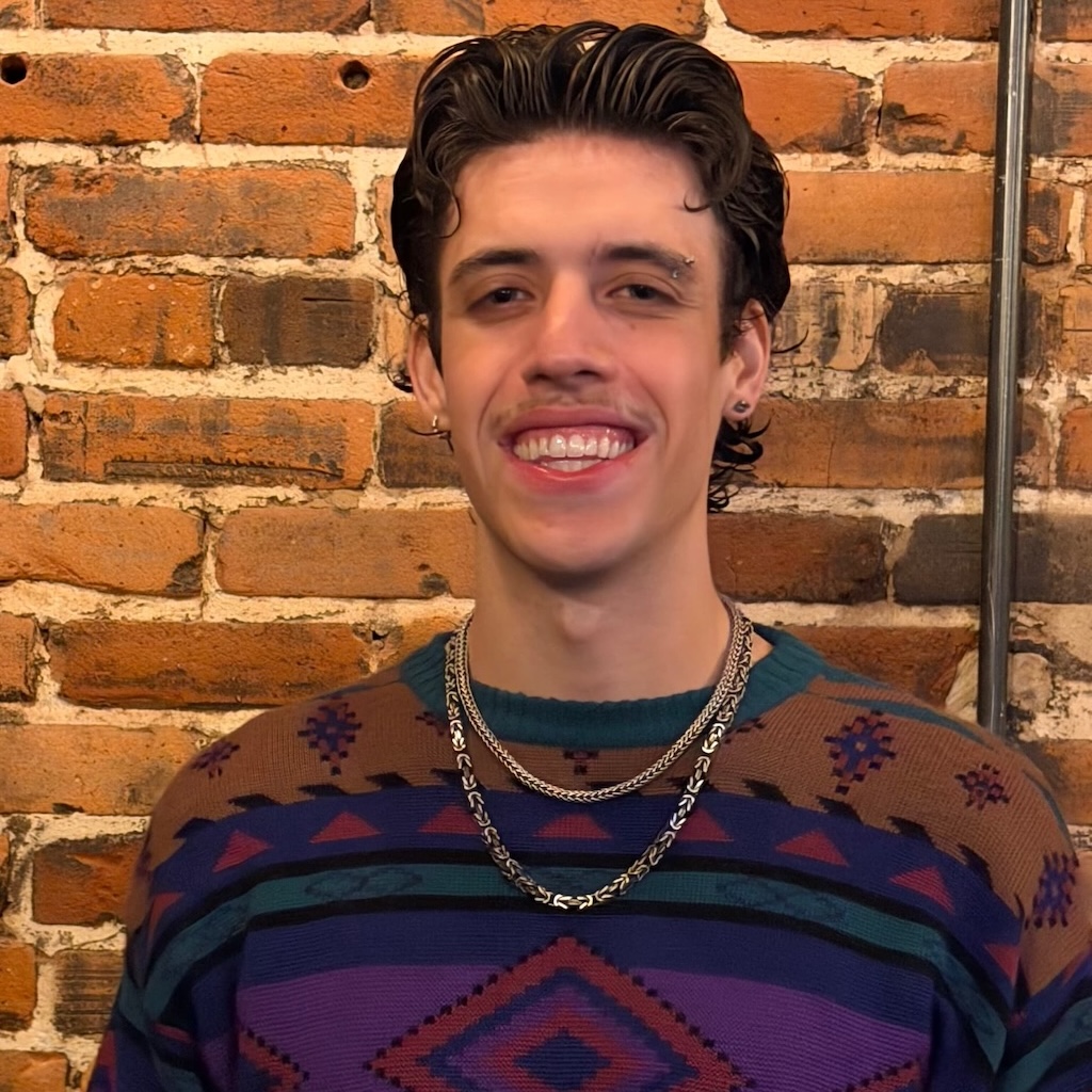 Man standing in front of brick background.