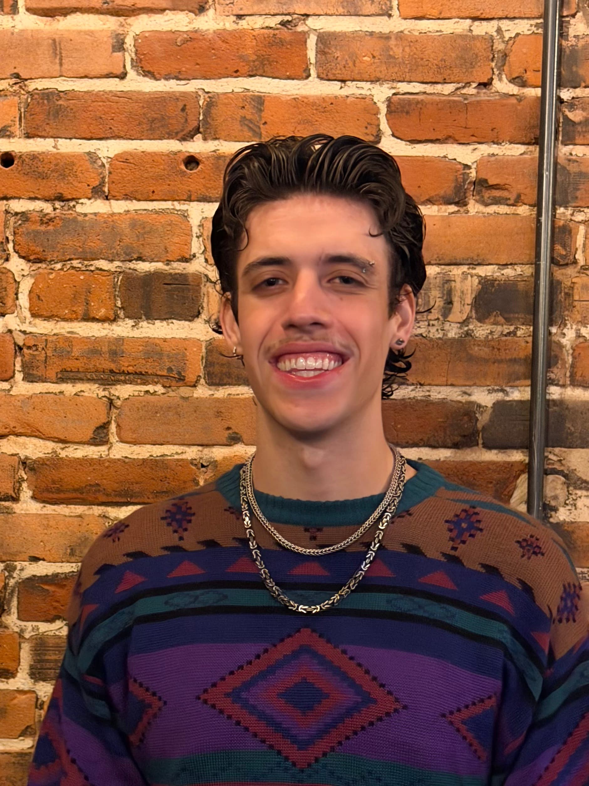 Man in front of brick background.